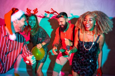 Bir grup neşeli genç arkadaş yeni yıl partisinde karaoke söyleyip dans ederek eğleniyorlar.