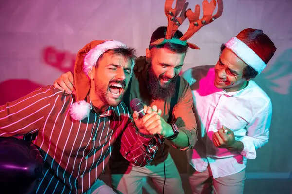 Bir grup neşeli erkek arkadaş yeni yıl partisinde karaoke söyleyip dans ederek eğleniyor.