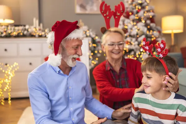 Büyükannem ve büyükbabam Noel 'de torunumla evde oynayıp Noel Baba şapkası ve geyik boynuzları takıp eğleniyorlardı.