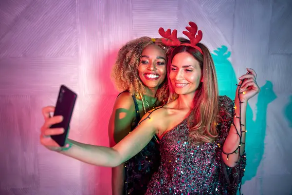 Eşcinsel lezbiyen çift yeni yıl partisinde eğleniyor, selfie çekiyor ve gece yarısı geri sayımında şampanya içiyor. Kız arkadaşlar dans edip eğleniyorlar.