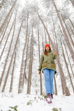 Güzel bir kadının karda yürürken dinlenmesi, kış tatilini dağlarda geçirmesi.