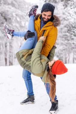 Çift kış tatilinde eğleniyor, erkek arkadaş kız arkadaşını kaldırıyor ve onu baş aşağı tutarken karlı kış günlerinde dağlarda dışarıda vakit geçiriyor.