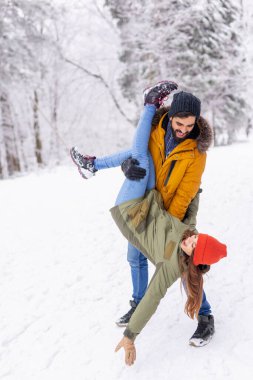 Çift kış tatilinde eğleniyor, erkek arkadaş kız arkadaşını kaldırıyor ve onu baş aşağı tutarken karlı kış günlerinde dağlarda dışarıda vakit geçiriyor.