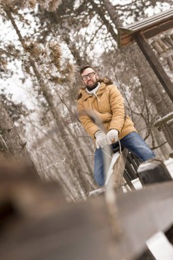 Birbirine aşık bir çift oyun alanında eğleniyor, tahterevallide oynuyor ve karlı kış gününün tadını çıkarıyor.