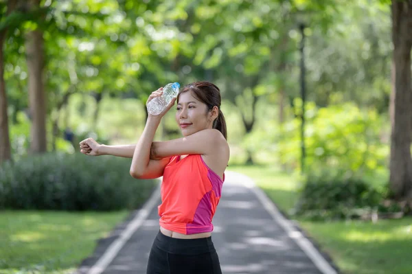 Glad Asiatisk Kvinnlig Löpare Värmer Upp Utomhus Håller Vattenflaska Parken — Stockfoto