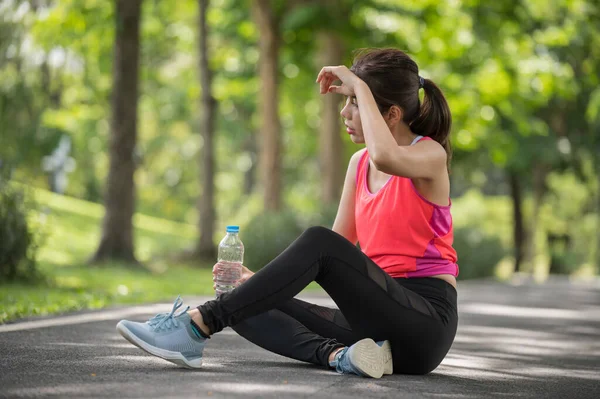 Asian female runner tired after running in the park, Health and lifestyle concept