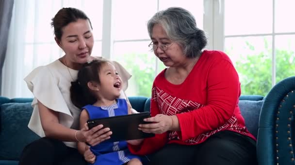 妈妈和奶奶用平板电脑教孩子在家里做作业 亚洲快乐家庭教育的理念 — 图库视频影像