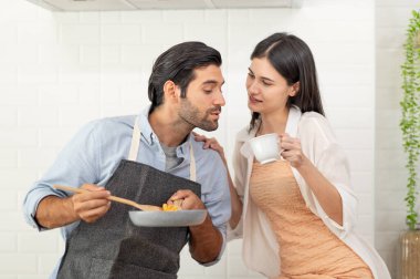 Mutlu çift evde yemek hazırlıyor, genç çift mutfak tezgahında sebze kesiyor, aşık erkek ve kadın.