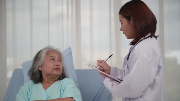 Aziatische Verpleegster Controleren Van Geschiedenis Van Ziekte Oudere Patiënt Bed — Stockvideo