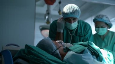Doktor oksijen maskeli bir hastayı hayata döndürüyor. Hastanedeki yatakta dinleniyor. Kalp masajı kardiyopulmoner canlandırma işlemi.