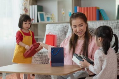 Mutlu Asyalı aile çocukları annesine hediye veriyor, hediye kutusu ve alışveriş torbaları, Noel ve yeni yıl çocukları konsepti.