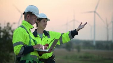 Rüzgar türbini tarlasında çalışan ve bilgisayar kullanan mühendisler, rüzgar türbinleri temiz enerji kaynağı, elektrik ve sanayi çevresi için eko teknolojisi üretiyor.
