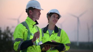 Rüzgar türbini çiftliğinde çalışan ve tablet kullanan mühendisler, rüzgar türbinleri temiz enerji kaynağı, elektrik ve sanayi çevresi için eko teknolojisi üretiyor.