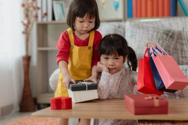Kolları havada mutlu Asyalı çocuk alışveriş torbaları, hediye kutusu Noel ve yeni yıl çocuğu konsepti