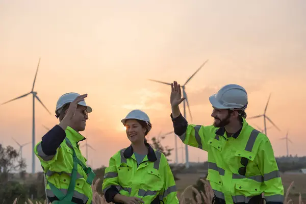 Team of engineers working on site in wind turbine farm, Wind turbines generate clean energy source, Eco technology for electric, industry environment