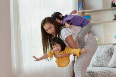 Anne evde kızıyla eğleniyor ve oynuyor, mutlu Asyalı çocuk, aile kavramı