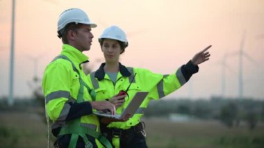 Rüzgar türbini tarlasında çalışan ve bilgisayar kullanan mühendisler, rüzgar türbinleri temiz enerji kaynağı, elektrik ve sanayi çevresi için eko teknolojisi üretiyor.