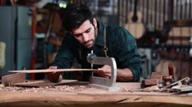 Luthier ahşap müzikal yapıyor ve çalışma odasında el aletleriyle geleneksel aletler kullanıyor.