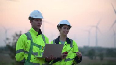 Rüzgar türbini tarlasında çalışan ve bilgisayar kullanan mühendisler, rüzgar türbinleri temiz enerji kaynağı, elektrik ve sanayi çevresi için eko teknolojisi üretiyor.