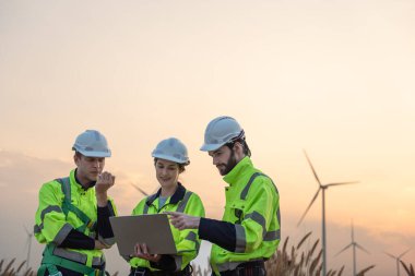 Rüzgar türbini çiftliğinde çalışan ve tablet kullanan mühendisler, rüzgar türbinleri temiz enerji kaynağı, elektrik ve sanayi çevresi için eko teknolojisi üretiyor.
