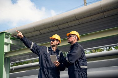 Rafineri endüstrisi, petrol ve gaz rafinerisi fabrikasında tabletle çalışan mühendis, Petrokimya fabrikası