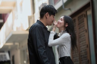 Asyalı genç çift birbirini arıyor, erkek ve kadın birlikte vakit geçiriyorlar.