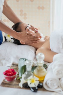 Genç Asyalı kadın spa salonunda masaj yaptırıyor, keyif alıyor ve rahatlatıyor, sağlıklı bir konsept.