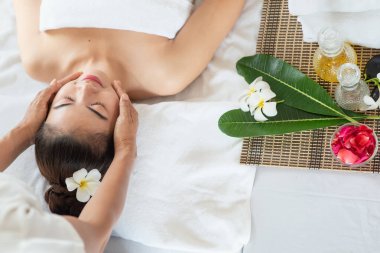 Genç Asyalı kadın spa salonunda masaj yaptırıyor, keyif alıyor ve rahatlatıyor, sağlıklı bir konsept.