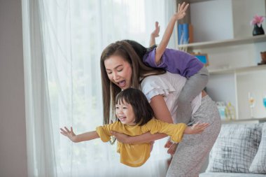 Anne evde kızıyla eğleniyor ve oynuyor, mutlu Asyalı çocuk, aile kavramı