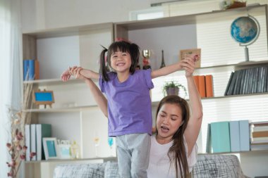 Anne evde kızıyla eğleniyor ve oynuyor, mutlu Asyalı çocuk, aile kavramı