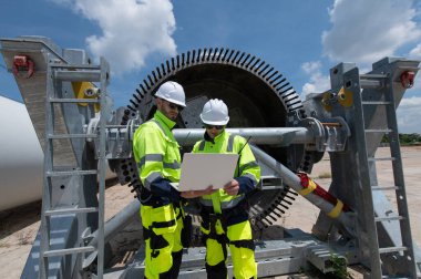 Rüzgâr türbini bakım ve onarım teknisyeni, mühendis türbinleri kontrol ediyor. Rüzgar türbini çiftliğinde bakım ve temiz güç jeneratörü sistemi çalışıyor.