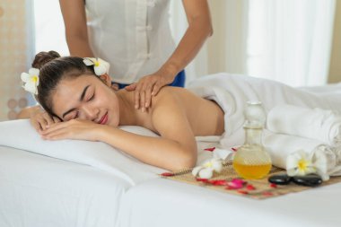 Genç Asyalı kadın spa salonunda masaj yaptırıyor, keyif alıyor ve rahatlatıyor, sağlıklı bir konsept.