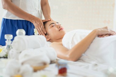 Genç Asyalı kadın spa salonunda masaj yaptırıyor, keyif alıyor ve rahatlatıyor, sağlıklı bir konsept.