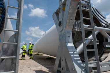 Rüzgâr türbini bakım ve onarım teknisyeni, mühendis türbinleri kontrol ediyor. Rüzgar türbini çiftliğinde bakım ve temiz güç jeneratörü sistemi çalışıyor.