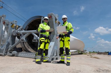 Rüzgâr türbini bakım ve onarım teknisyeni, mühendis türbinleri kontrol ediyor. Rüzgar türbini çiftliğinde bakım ve temiz güç jeneratörü sistemi çalışıyor.