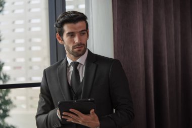 Dijital tablet ve iş konsepti kullanan takım elbiseli yakışıklı iş adamının portresi