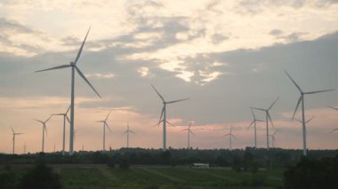 Elektrik üretim istasyonu, günbatımında tarımsal alanlarda rüzgar türbinleri, Alternatif Enerji Yel Değirmeni Çiftliği, Temiz Enerji Konsepti.