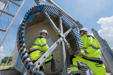 Rüzgâr türbini bakım ve onarım teknisyeni, mühendis türbinleri kontrol ediyor. Rüzgar türbini çiftliğinde bakım ve temiz güç jeneratörü sistemi çalışıyor.