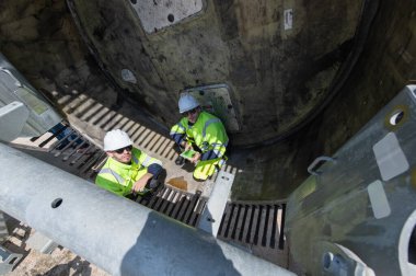 Rüzgâr türbini bakım ve onarım teknisyeni, mühendis türbinleri kontrol ediyor. Rüzgar türbini çiftliğinde bakım ve temiz güç jeneratörü sistemi çalışıyor.