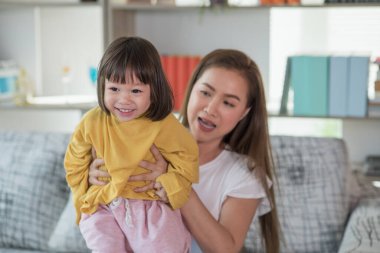 Anne evde kızıyla eğleniyor ve oynuyor, mutlu Asyalı çocuk, aile kavramı