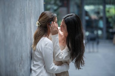 Mutlu Asyalı lezbiyen lgbtq çifti birbirini öpüyor, birlikte zaman geçiriyorlar.