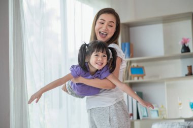 Anne evde kızıyla eğleniyor ve oynuyor, mutlu Asyalı çocuk, aile kavramı