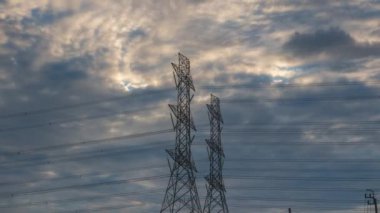 Gün batımında yüksek voltajlı elektrik direği yapısı zaman aşımı