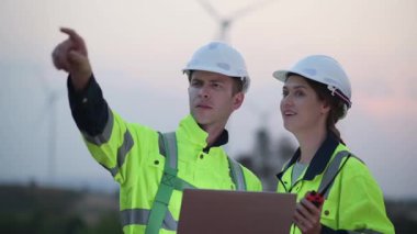 Rüzgar türbini tarlasında çalışan ve bilgisayar kullanan mühendisler, rüzgar türbinleri temiz enerji kaynağı, elektrik ve sanayi çevresi için eko teknolojisi üretiyor.