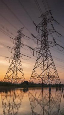 Yüksek voltajlı elektrik direği yapısı veya günbatımında yüksek voltajlı elektrik iletim kulesi zaman aşımı