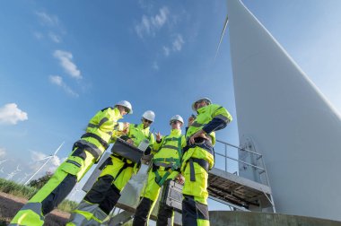Rüzgâr türbini bakım ve onarım teknisyeni, mühendis türbinleri kontrol ediyor. Rüzgar türbini çiftliğinde bakım ve temiz güç jeneratörü sistemi çalışıyor.
