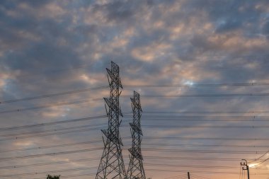 Yüksek voltajlı elektrik direği yapısı ya da günbatımında yüksek voltajlı elektrik iletim kulesi