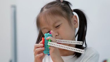 Çocuklar inşaat bloklarıyla oynuyor, çocuklar renkli plastik tuğlalarla oynuyor ve inşa ediyorlar. Erken öğrenme ve geliştirme.