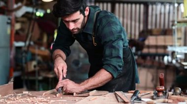 Luthier ahşap müzikal yapıyor ve çalışma odasında el aletleriyle geleneksel aletler kullanıyor.