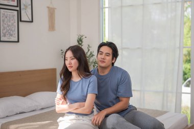 Genç Asyalı koca karısını rahatlattı, karısı kızgın ve kocasına somurtuyor. Bu arada erkek de aile sorunları kavramını düzeltmeye çalışıyor..